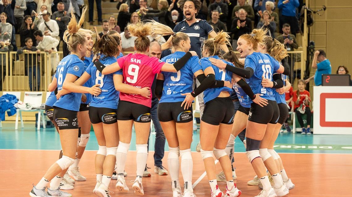 Kreistanz. Wiesbadens Volleyballerinnen feiern ihren vierten Sieg in Folge. Trainer Benedikt Frank springt am höchsten.