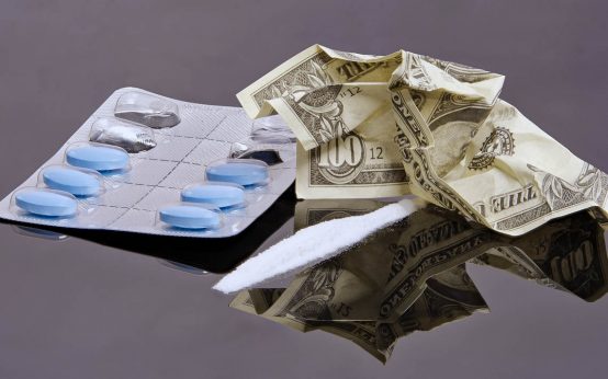 Tabletten, Kokain, Geld, Drogen Rauschgilft auf einem Tisch.