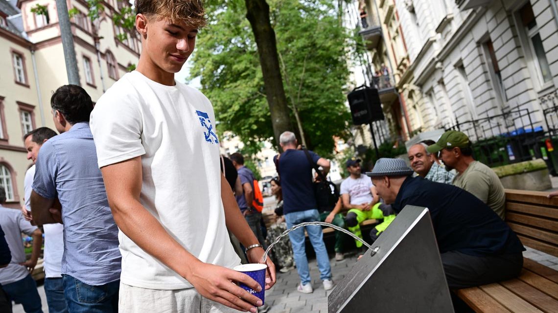 Hitzehilfe: Refill-Station in der Gerichtstraße, Jugendlicher füllt Becher auf.